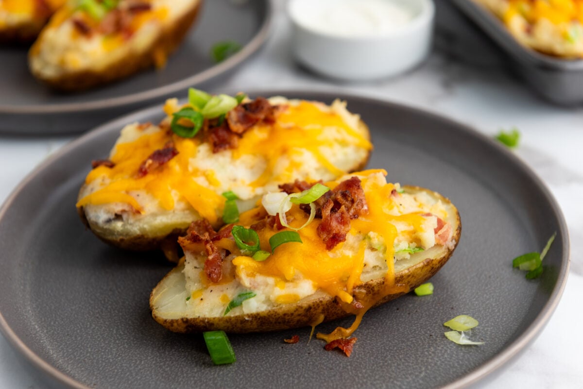 A delicious overhead shot of a plate loaded with twice-baked potatoes, garnished with green scallions.