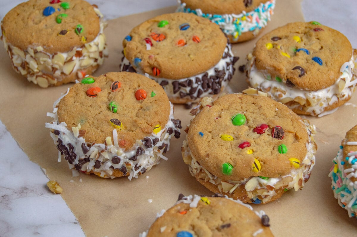 Assorted ice cream sandwiches with various cookie flavors and toppings displayed on parchment paper following a classic recipe.