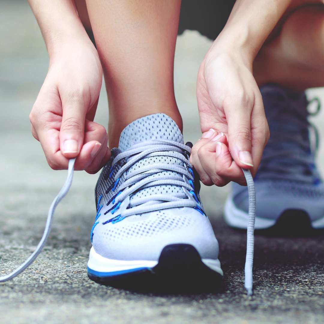 Person tying the laces of a running shoe for their 30 minute workout.