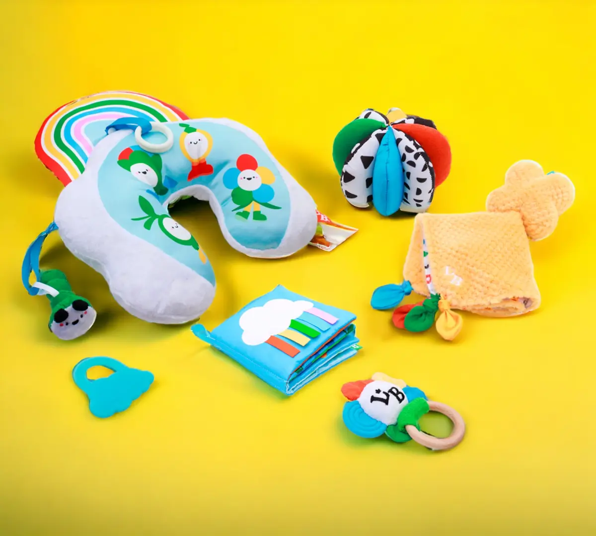 A collection of colorful baby toys and accessories on a yellow background.