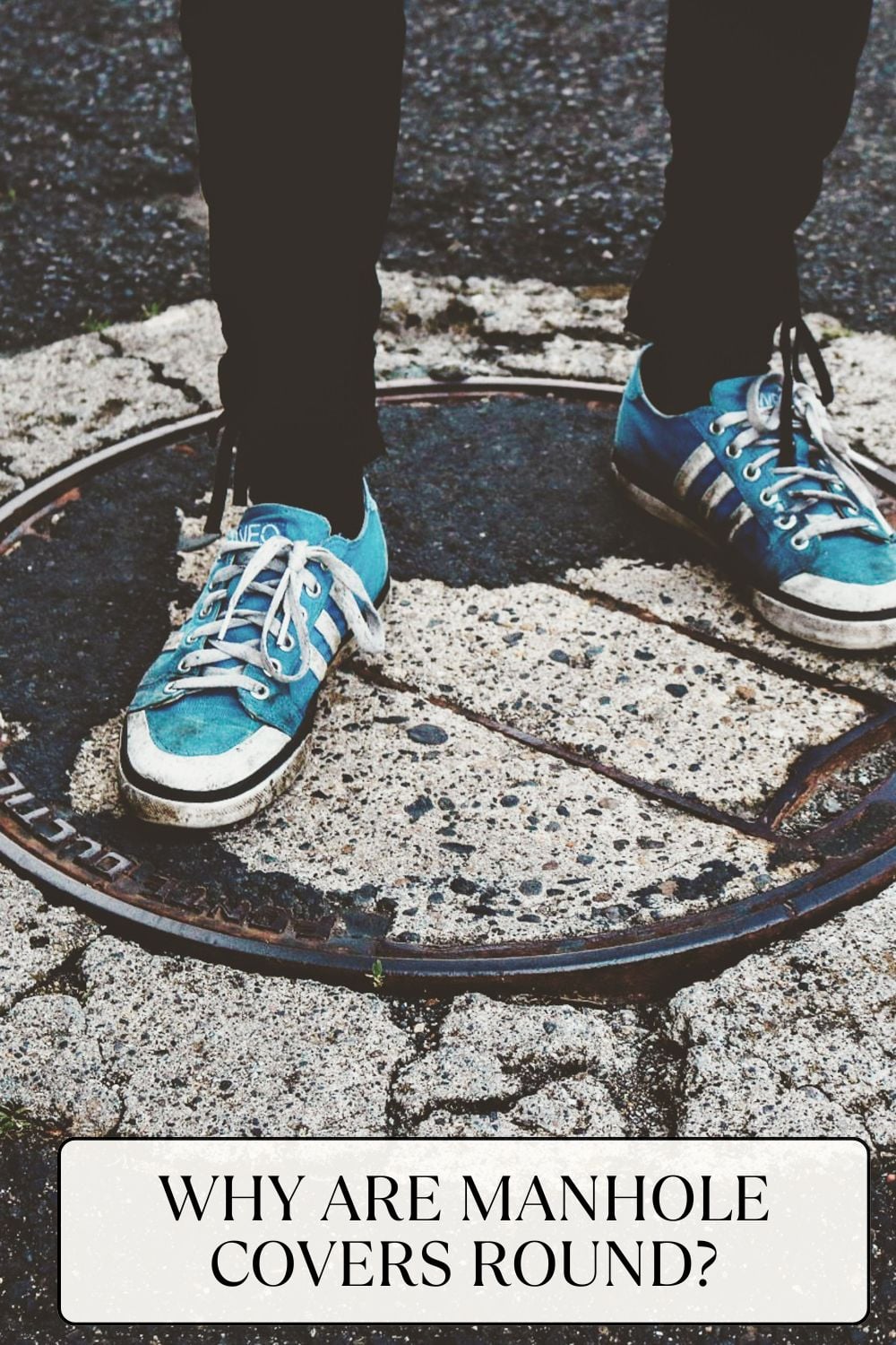 Person standing on a round manhole cover, sporting blue sneakers. Text at the bottom of the image asks, "WHY ARE MANHOLE COVERS ROUND?