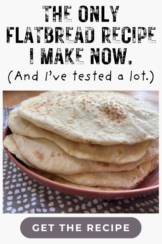 A plate of homemade flatbreads stacked on a patterned cloth with text highlighting our easy yogurt flatbread recipe—a must-try for soft and delicious results every time.