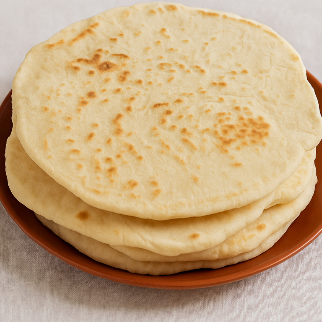 A stack of plain, round yogurt flatbread sits on a brown plate atop a light-colored surface—an easy flatbread recipe perfect for making no yeast flatbreads at home.