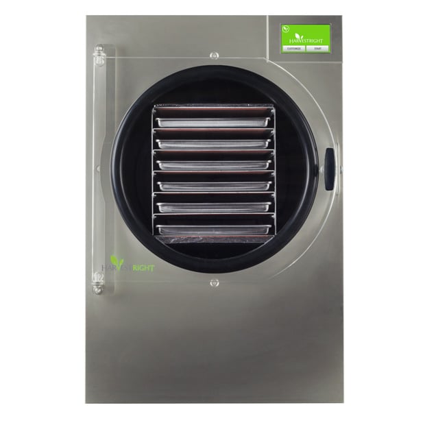 A front view of a stainless steel Harvest Right freeze dryer with a circular door, revealing six metal trays inside—perfect for preserving food and using your next coupon code.