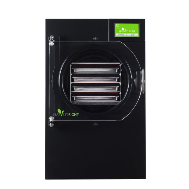 Front view of a black Harvest Right freeze dryer with a transparent door, four metal trays inside, and a small digital display in the top right corner—perfect for preserving food and saving more with a Harvest Right coupon code.