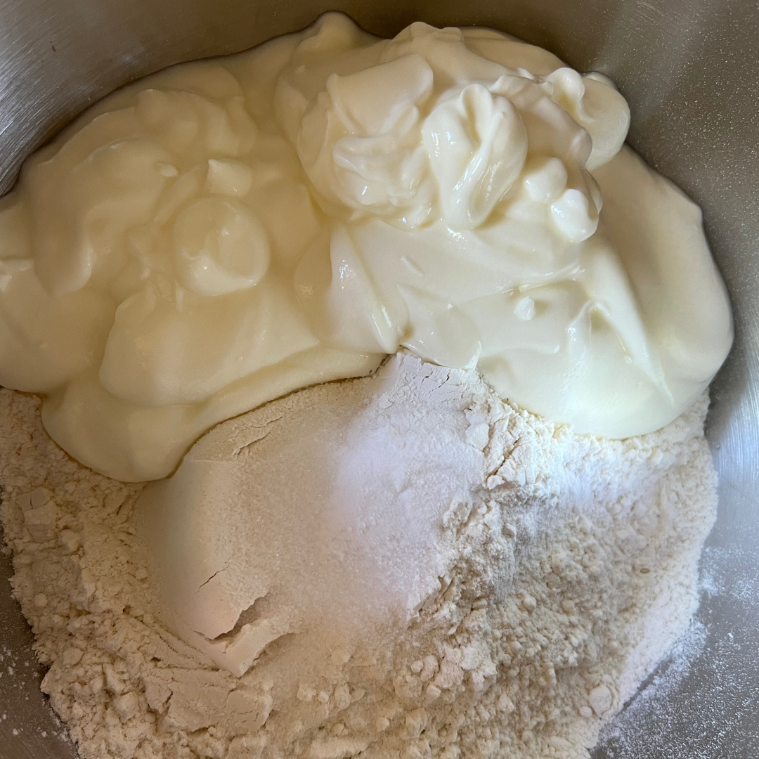 A close-up of thick white yogurt and flour in a mixing bowl, ready to be combined for an easy Yogurt Flatbread recipe—perfect for making no yeast flatbreads at home.