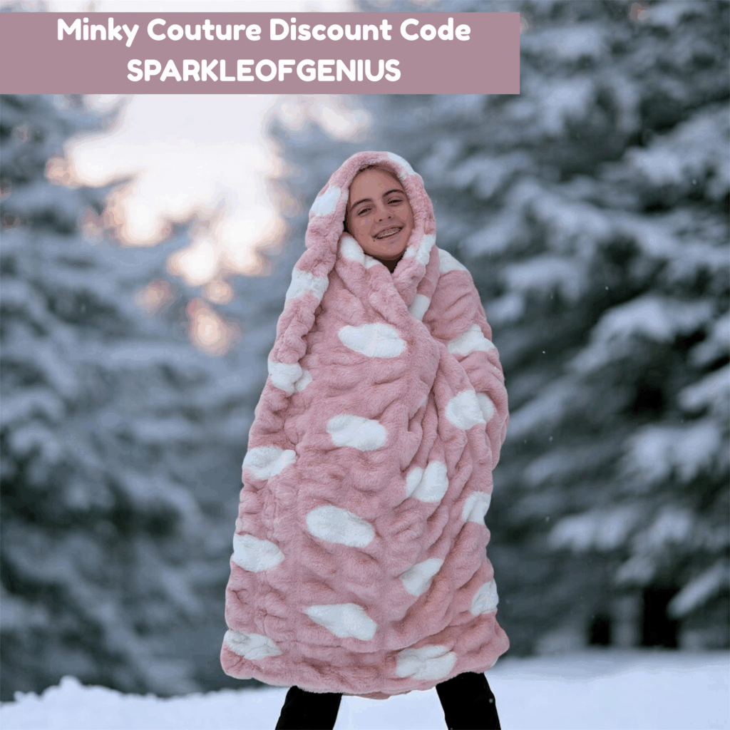 Girl wrapped in a pink Minky Couture blanket in the snow with text promoting Minky Couture discount code SPARKLEOFGENIUS.