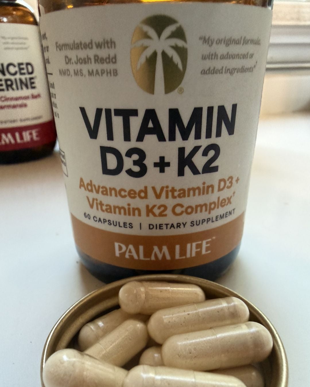 Palm Life Vitamin D3 + K2 supplement with capsules displayed in front of the bottle