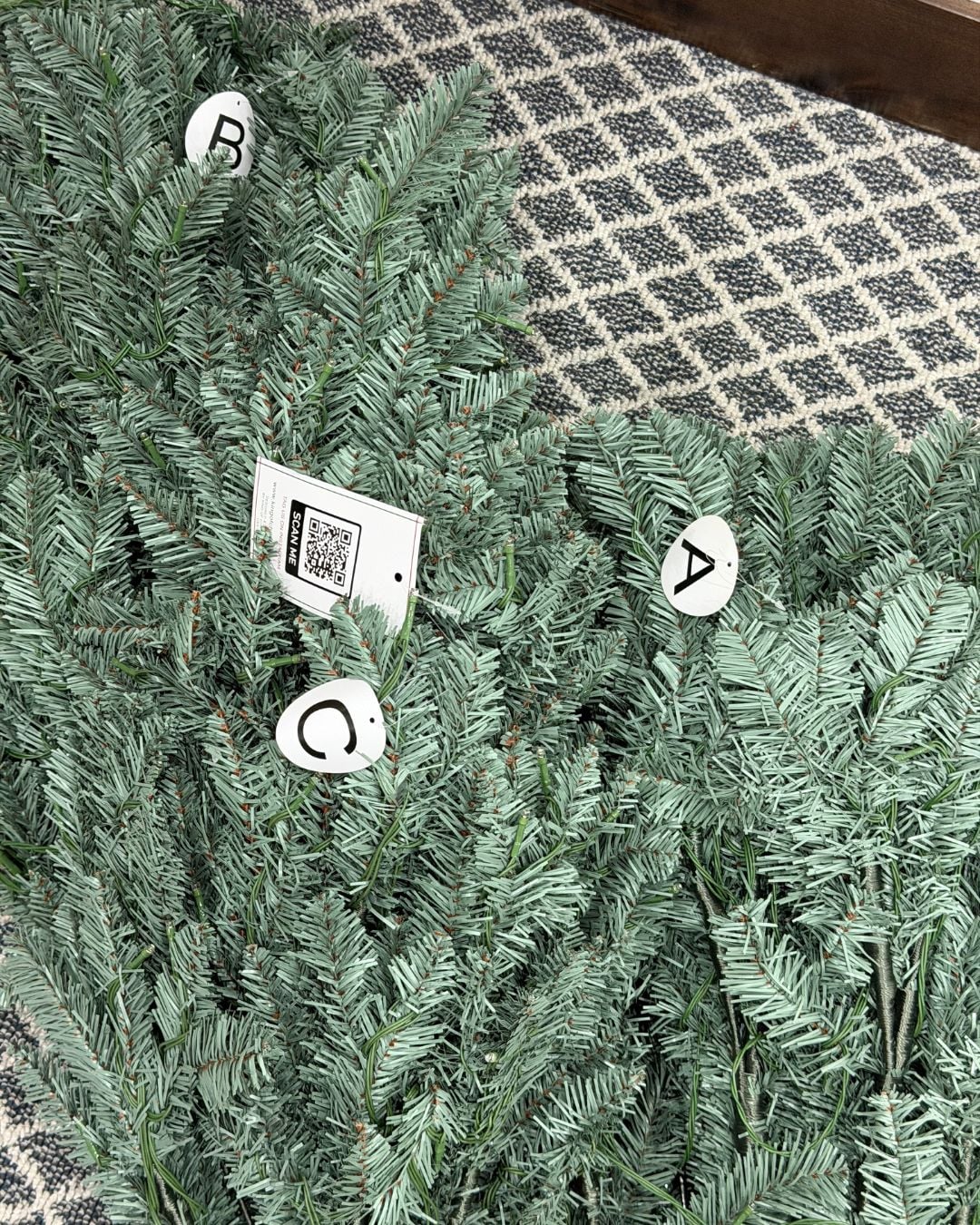 Three labeled sections of the King of Christmas Tribeca Blue Spruce tree ready for easy assembly.